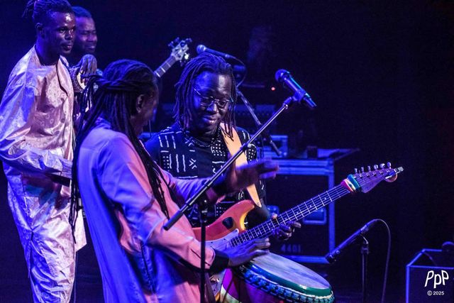 Zale Seck, djembé en bandoulière, face au guitariste du groupe.